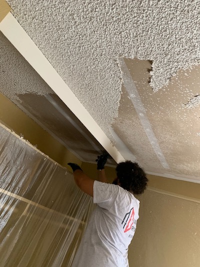image if man removing drywall texture